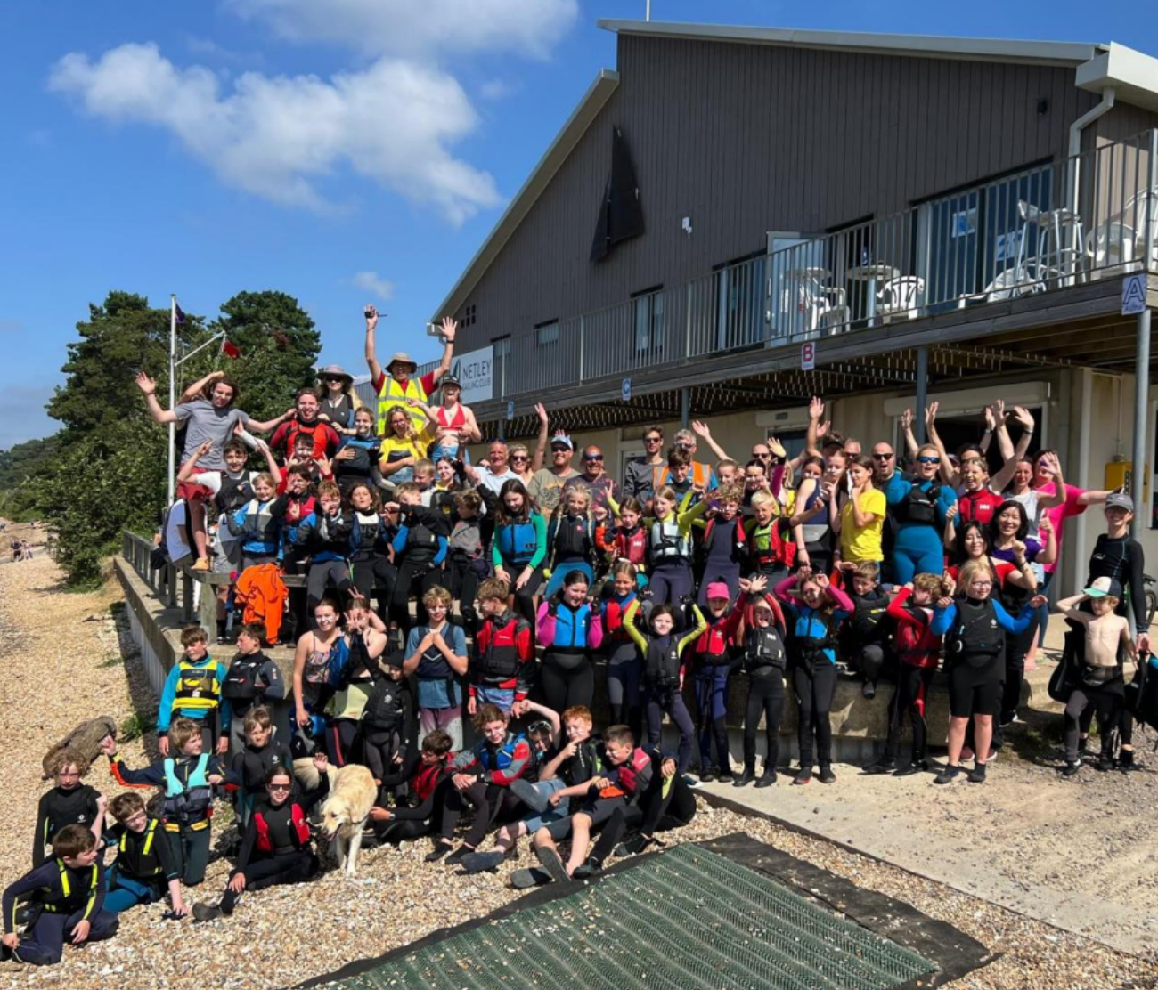 Group photo of Youth Week participants, volunteers and families outside the Netley Sailing Club clubhouse.